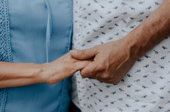 Two people holding hands, no faces shown